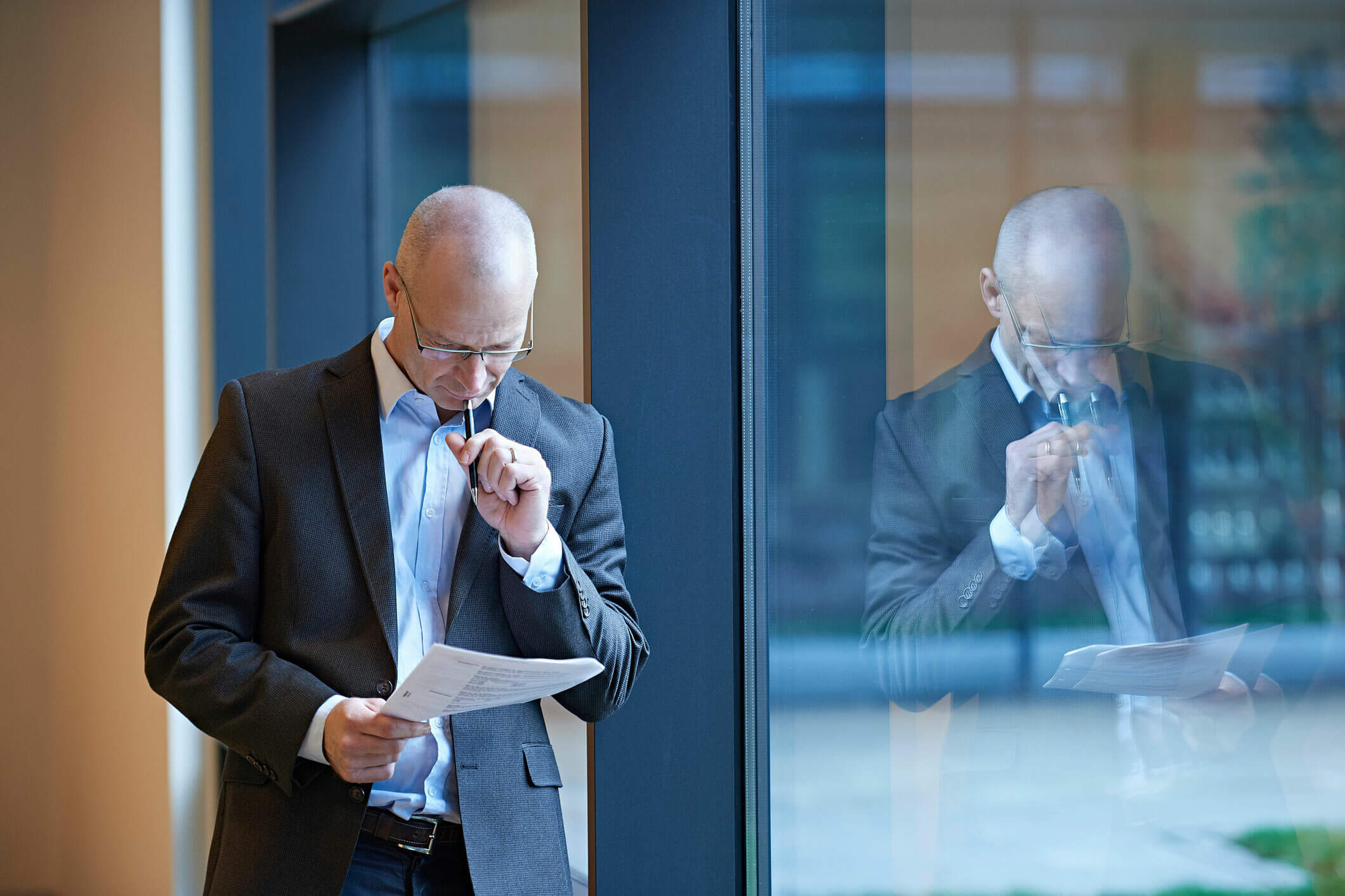 A business man reading by a window.