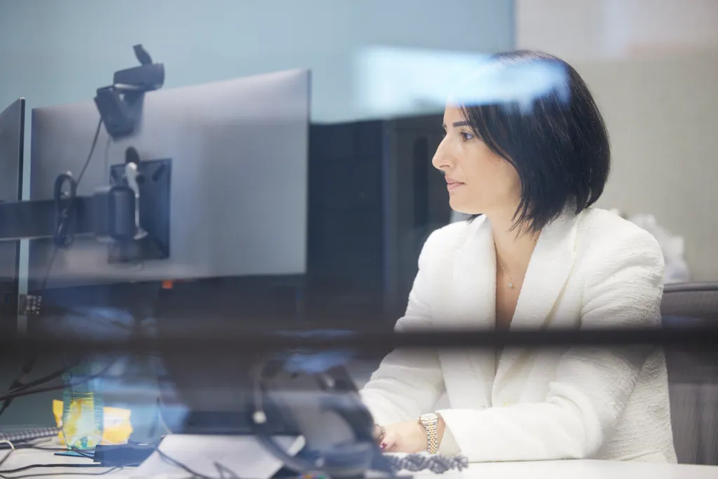 About: Focused professional at desk facing her computer
