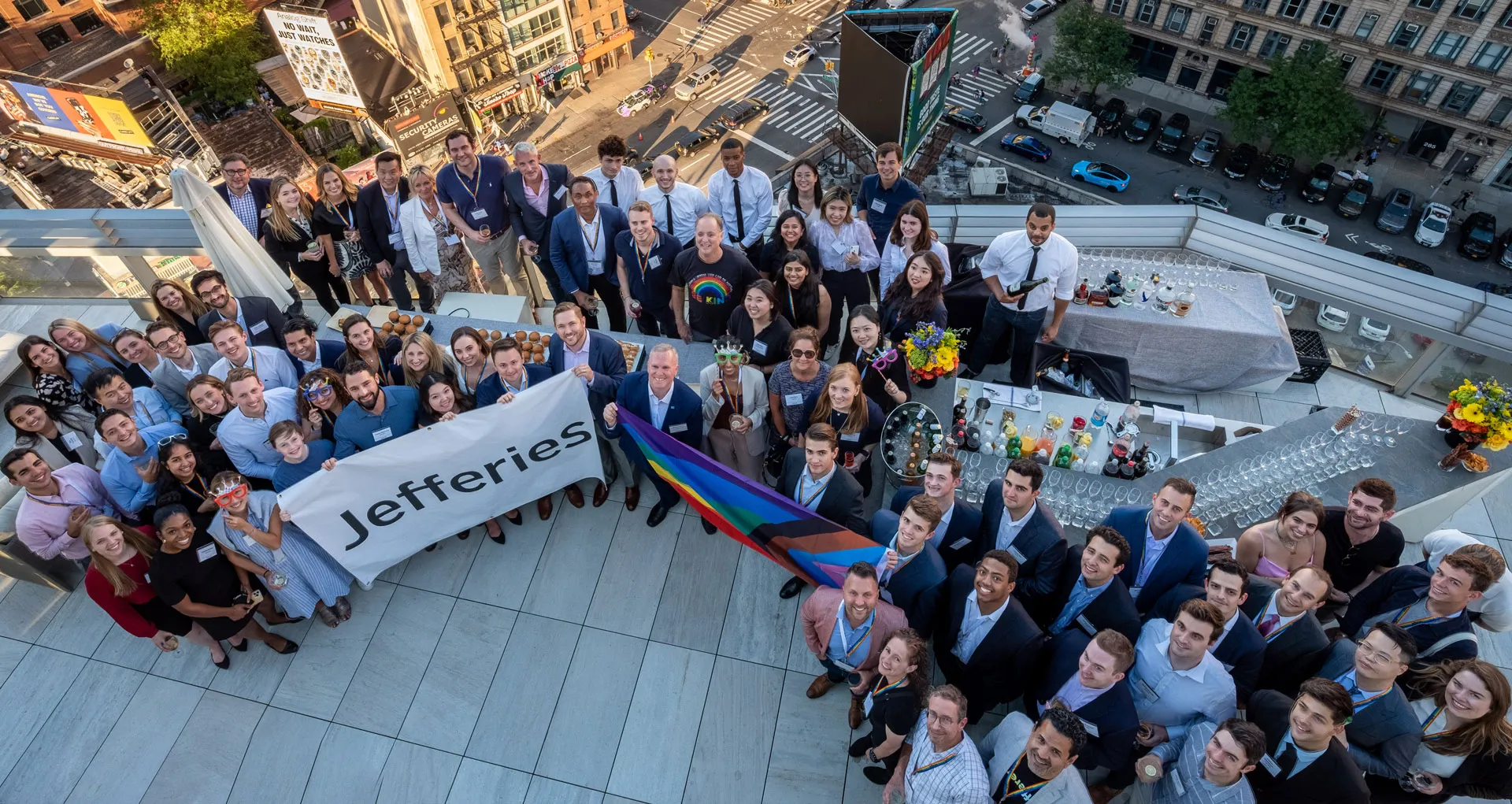 Pride event group photo on rooftop with Jefferies logo banner