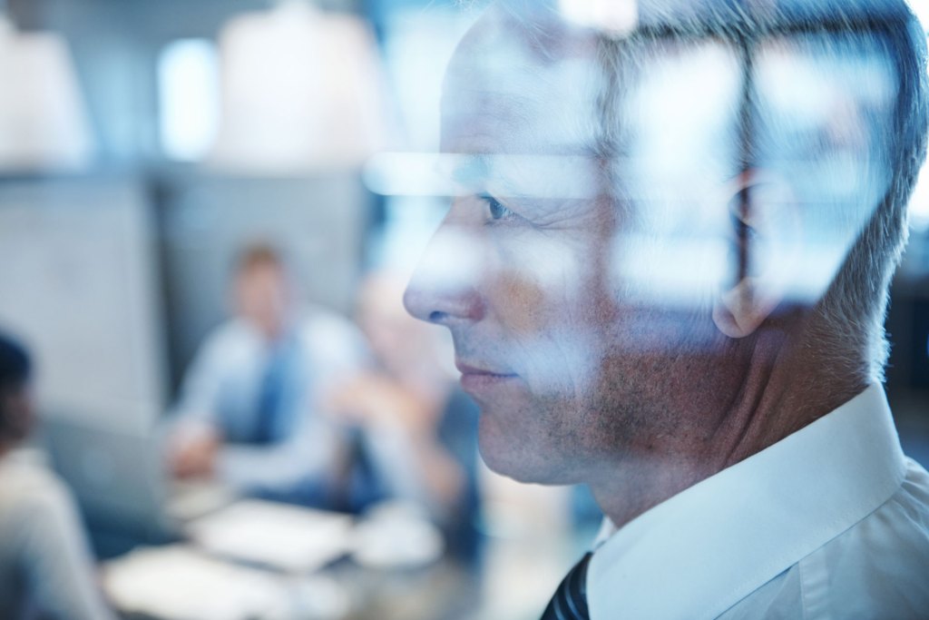 Profile of white business man with other co-workers in the bakcround