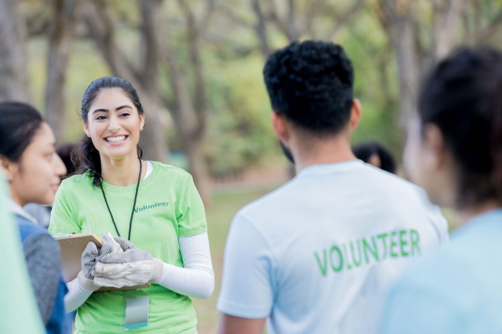 Two people with volunteer tshirts on outdoors